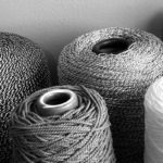 Monochrome photograph showing the different textural qualities of various spools of string.