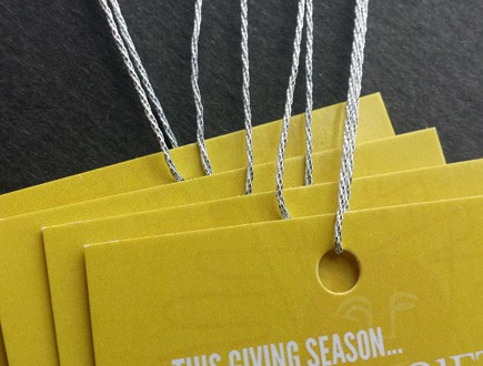 Yellow tags with tone-on-tone pattern design strung with 3-ply silver lamé.
