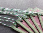 Maroon tags with snowflake graphic and two-tone green border strung with green bakery twine.