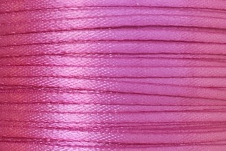 A spool of 1/16" double-faced satin ribbon in hot pink.