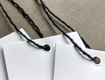 Eyeletted tags strung with our heavyweight black cotton string.