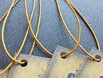 Weathered-looking tags strung with gold non-fray elastic.