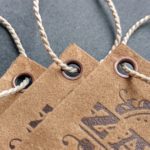 Tags of suede-like cover stock featuring debossed leather-look design and copy, reinforced with our antique copper eyelets and strung with our heavyweight bell cord.