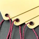 Round-cornered tags of butter yellow double-thick cover stock reinforced with our antique brass eyelets and strung with our wine-tone heavyweight cotton.