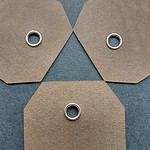 Tags of brown cover stock reinforced with our nickel eyelets.