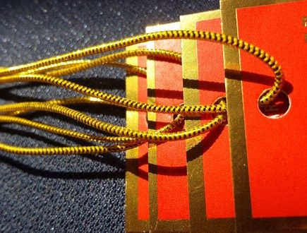 Vermilion tags with a gold foil border strung with our gold metallic elastic.