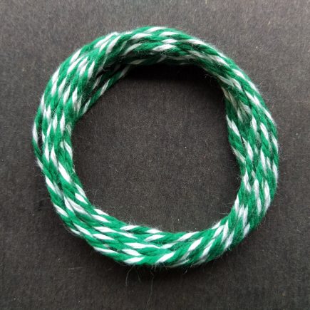 Coil of heavyweight variegated green-white cotton string.