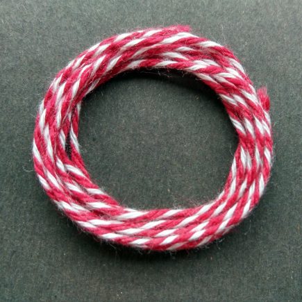 Coil of heavyweight variegated red-white cotton string.
