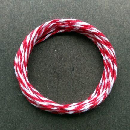 Coil of middle-weight variegated red-white cotton string.