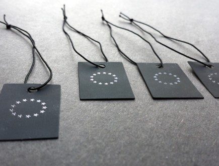 Black tags with black copy strung with black non-fray elastic.