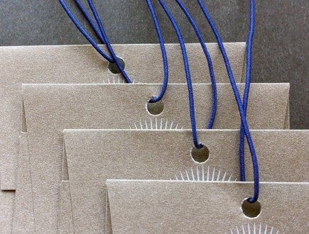 Brown paper envelopes strung with blue non-fray elastic.