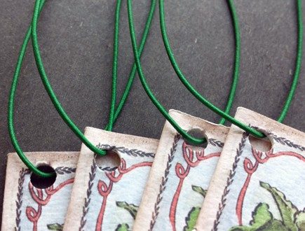 Stitched booklets strung with green non-fray elastic.
