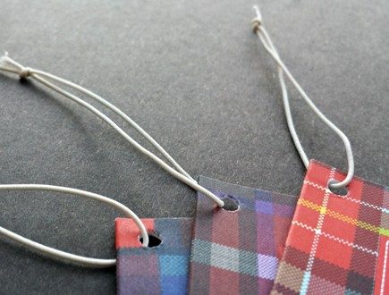 Plaid tags strung with white non-fray elastic.