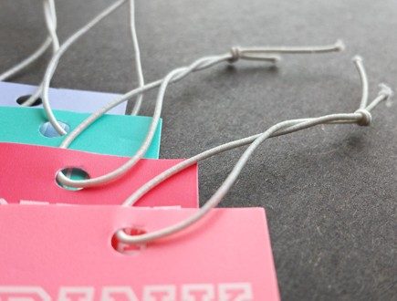 Pastel-colored tags strung with white non-fray elastic.