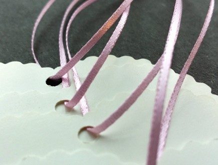 Heart-shaped die-cut tags with scalloped edges strung with light pink 1/16