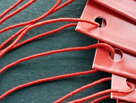 Folded red tags strung with standard elastic in red.