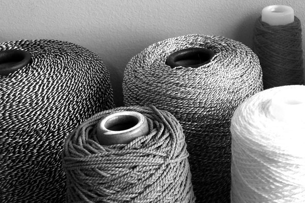 string-featured Monochrome photograph showing the different textural qualities of various spools of string.